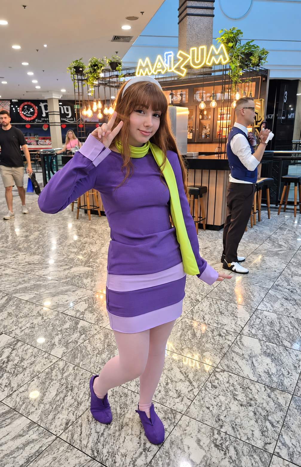 Cosplayer com vestido roxo e lenço verde