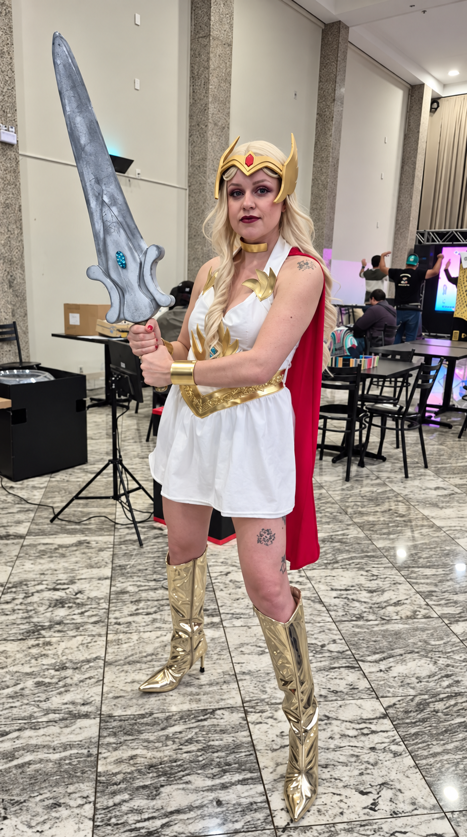 Cosplayer heroína com espada e capa vermelha